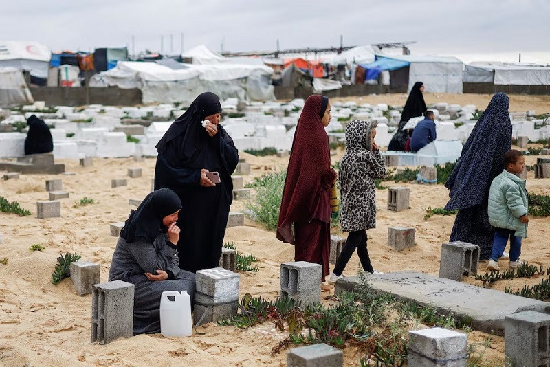 Palestinian women visit graves of people who were killed in the ongoing conflict between Israel and Palestinian group Hamas, on the day of Eidul Fitr, in Rafah, in the southern Gaza Strip April 10, 2024. PHOTO: REUTERS