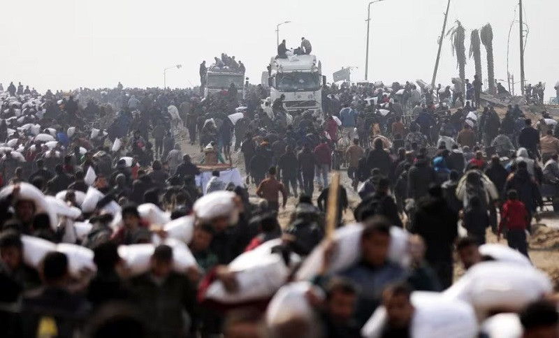 palestinians carry bags of flour they grabbed from an aid truck near an israeli checkpoint as gaza residents face crisis levels of hunger in gaza city february 19 2024 photo reuters