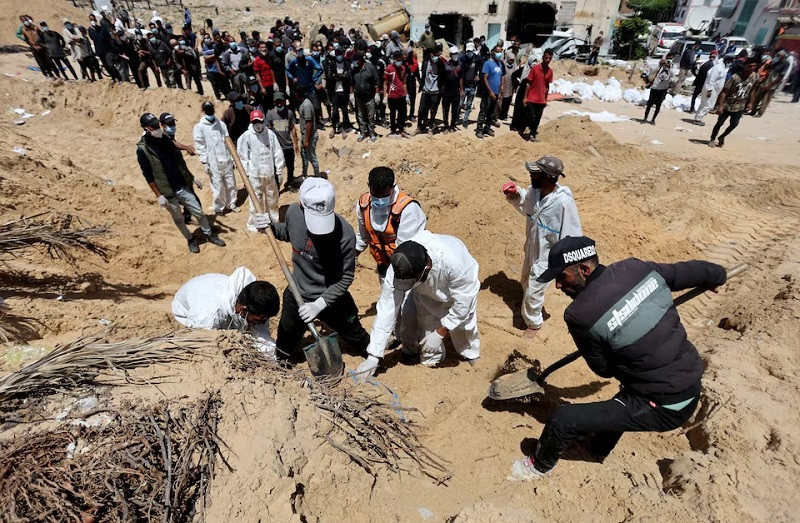 people work to move into a cemetery bodies of palestinians killed during israel s military offensive and buried at nasser hospital in khan younis in the southern gaza strip april 21 2024 photo reuters