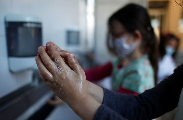 schoolchildren clean their hands at the private primary school jeanne d arc in saint maur des fosses near paris amid the coronavirus disease covid 19 outbreak in france march 30 2021 photo reuters