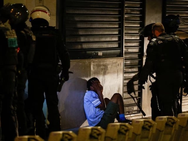 police identify a young person during the fifth night of protests following the death of nahel a 17 year old teenager killed by a french police officer in nanterre during a traffic stop in the champs elysees area in paris france july 2 2023 photo reuters