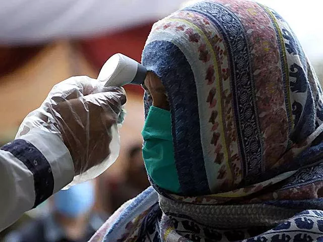 a pakistani official checks the body temperature of a woman photo afp a pakistani official checks the body temperature of a woman photo afp