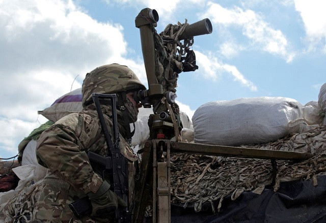 a service member of the ukrainian armed forces uses periscopes while observing the area at fighting positions on the line of separation near the rebel controlled city of donetsk ukraine april 17 2021 photo reuters
