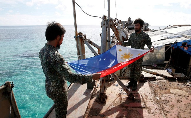 philippine marines fold a philippine national flag during a flag retreat at the brp sierra madre a marooned transport ship in the disputed second thomas shoal part of the spratly islands in the south china sea march 29 2014 photo reuters
