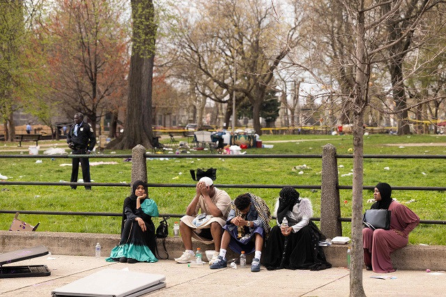 people sit on the edge of clara muhammad square after an eid celebration was broken up by a shooting in philadelphia pennsylvania photo afp