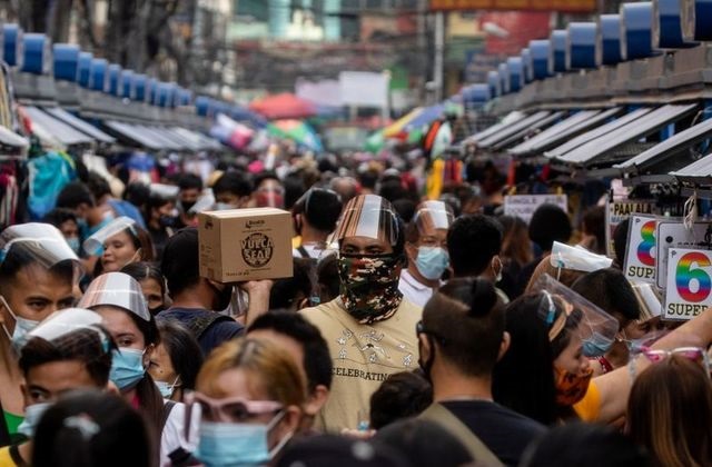filipinos wearing masks and face shields for protection against the coronavirus disease covid 19 walk along a street market in manila philippines december 3 2020 photo reuters