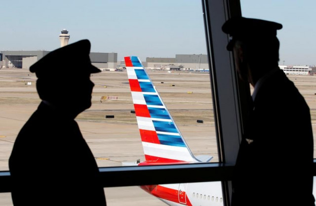 pilots talk as they look at the tail of an american airlines aircraft at dallas fort worth international airport february 14 2013 photo reuters file pilots talk as they look at the tail of an american airlines aircraft at dallas fort worth international airport february 14 2013 photo reuters file