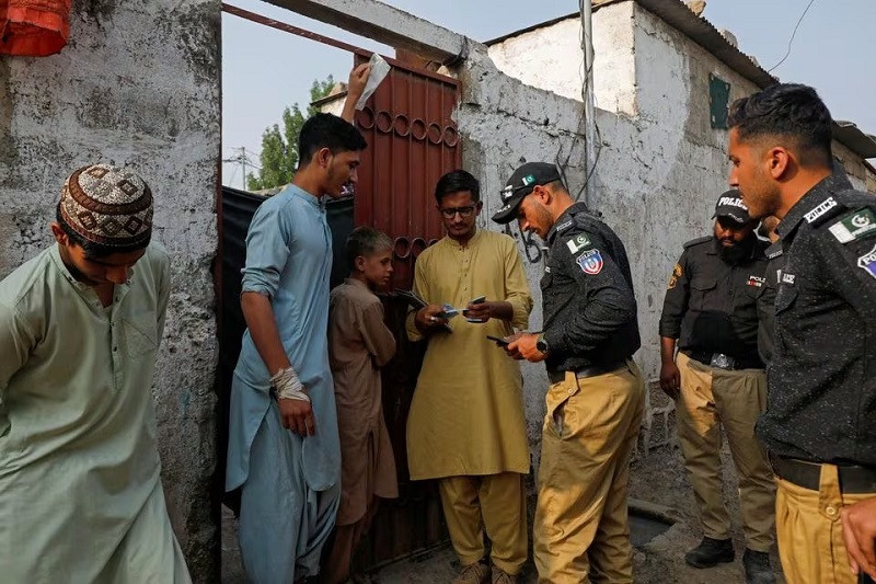 police officers nadra workers check the id cards of afghan citizens in an afghan camp on the outskirts of karachi november 21 2023 photo reuters