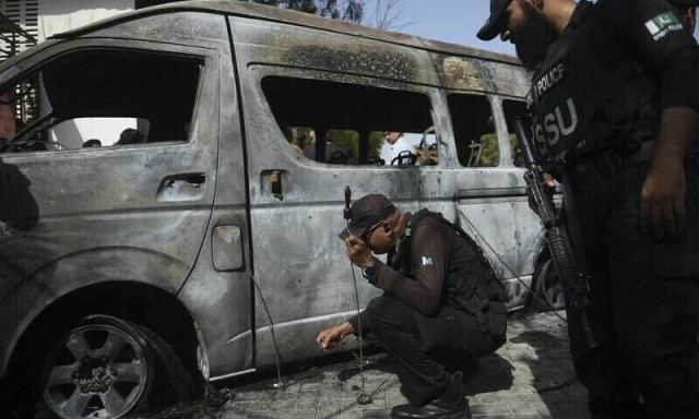 police inspect a site around damaged vehicles following a suicide bombing at a university in karachi on april 26 2022 photo afp police inspect a site around damaged vehicles following a suicide bombing at a university in karachi on april 26 2022 photo afp