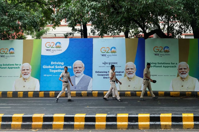 police officers walk past posters with the picture of india s prime minister narendra modi on the first day of the g20 summit in new delhi india september 9 2023 photo reuters police officers walk past posters with the picture of india s prime minister narendra modi on the first day of the g20 summit in new delhi india september 9 2023 photo reuters