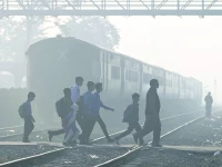 school children walk across a railway track engulfed in dense smog in lahore photo afp school children walk across a railway track engulfed in dense smog in lahore photo afp