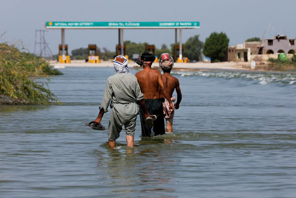 displaced people walk on flooded highway following rains and floods during the monsoon season in sehwan pakistan september 16 2022 reuters