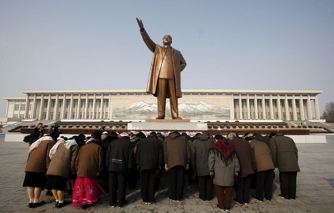 a group of people bow at the base of the giant bronze statue of the state founder and great leader kim il sung in the north korean capital of pyongyang february 26 2008 photo reuters