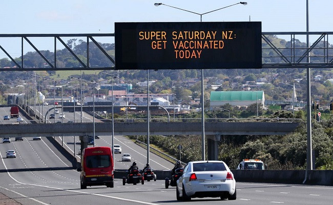 a sign on an auckland motorway urges people to get vaccinated at a coronavirus disease covid 19 vaccination clinic during a single day vaccination drive aimed at significantly increasing the percentage of vaccinated people in the country in auckland new zealand october 16 2021 photo reuters