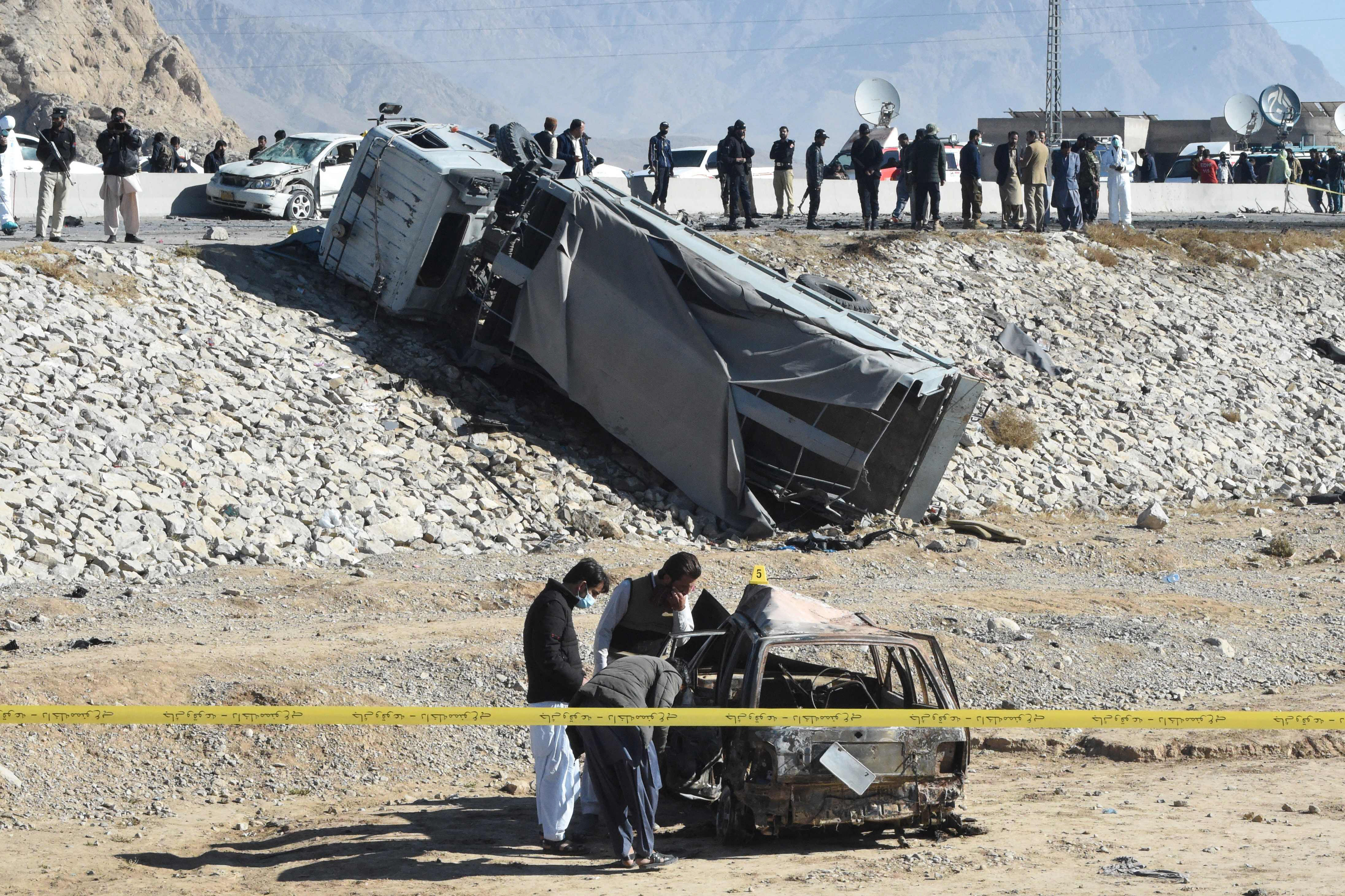 security officials inspect a burnt out car after a suicide bomb attack targeting a police truck in quetta photo afp