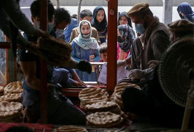 an afghan family waits for free bread distributed by the government outside a bakery during the coronavirus disease covid 19 outbreak in kabul afghanistan may 3 2020 picture taken may 3 2020 photo reuters