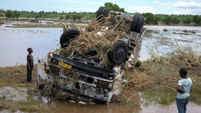 locals look at a wreck washed away during tropical storm ana on the flooded shire river at the village of thabwa in chikwawa district southern malawi january 26 2022 reuters eldson chagara file photo