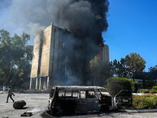 smoke billows from a building set ablaze by protesters in peshawar photo afp