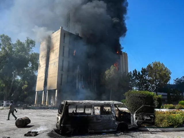 smoke billows from a building set ablaze by protesters in peshawar photo afp smoke billows from a building set ablaze by protesters in peshawar photo afp