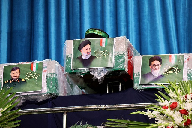 A picture of late Iranian President Ebrahim Raisi is seen on a casket during a funeral ceremony for him and his companions who were killed in a helicopter crash at Mosalia mosque in Tehran. PHOTO: AFP