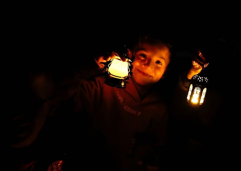 a child holds a lantern as displaced palestinians prepare their tents for ramadan in rafah in the southern gaza strip march 9 2024 photo reuters