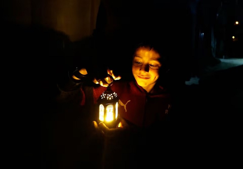 A child holds a lantern as displaced Palestinians prepare their tents for Ramadan, amid the ongoing conflict between Israel and the Palestinian group Hamas, in Rafah, in the southern Gaza Strip March 9, 2024. PHOTO: REUTERS