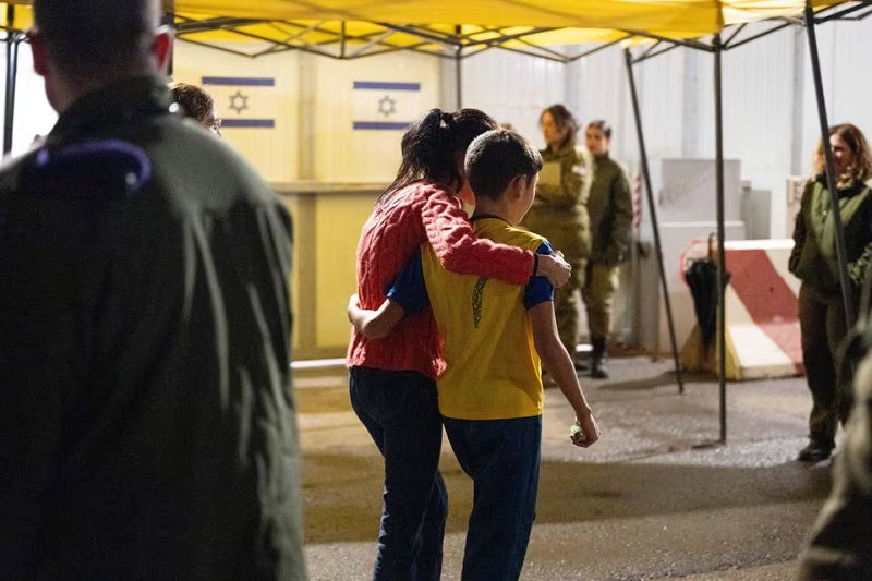 Eitan Yahalomi, 12, walks with his mother at the Kerem Shalom border crossing, after being released from Gaza. PHOTO: REUTERS