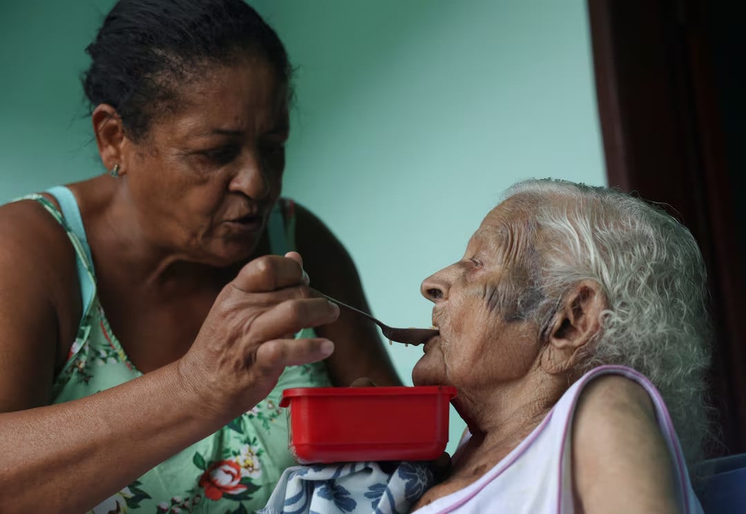 Doroteia Ferreira da Silva, 60, feeds her grandmother Deolira Gliceria Pedro da Silva, 119. Reuters.