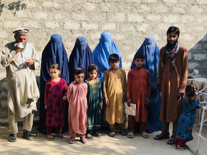 mohammed jafar 21 poses for a picture along with widows of his three brothers their children and his father in kunar afghanistan photo reuters