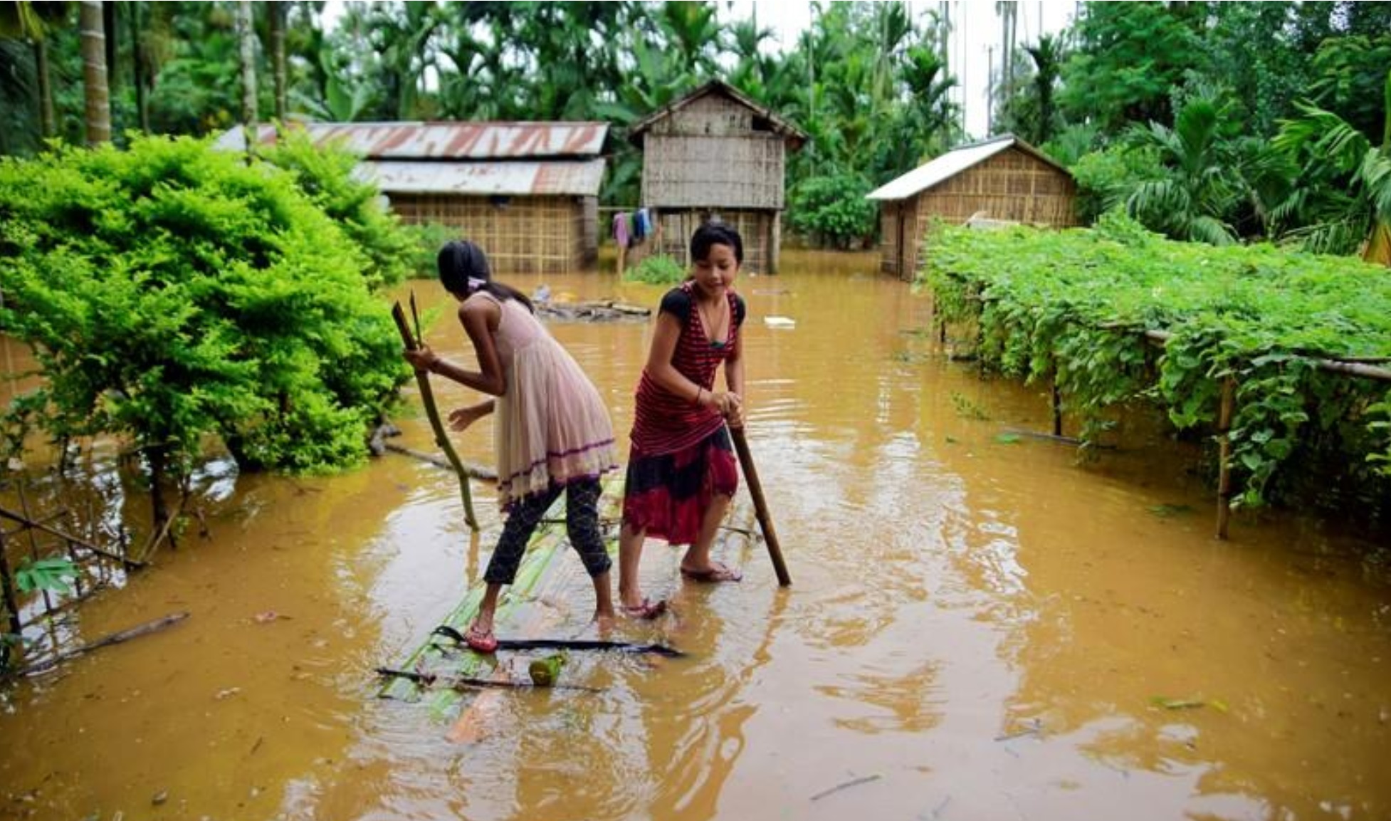 girls row a makeshift raft past submerged houses at a flood affected village in karbi anglong district in the northeastern state of assam india july 11 2019 photo reuters file