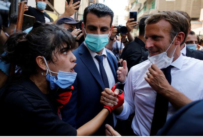 french president emmanuel macron listen to a resident as he visits a devastated street of beirut photo reuters file