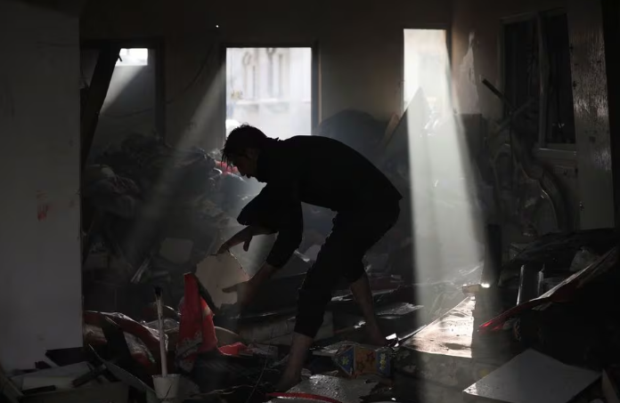 photo palestinian picks up debris on the site of an israeli strike at maghazi refugee camp in the central gaza strip amid the ongoing conflict between israel and the palestinian islamist group hamas january 3 2024 reuters