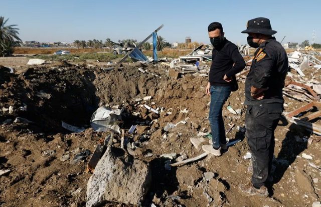 photo a fighter of the iraqi kataib hezbollah militia group and a man inspect the site of a u s airstrike in hilla iraq december 26 2023 reuters