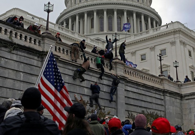 supporters of us president donald trump climb a wall during a protest against the certification of the 2020 presidential election results by the congress at the capitol in washington u s january 6 2021 picture taken january 6 2021 photo reuters