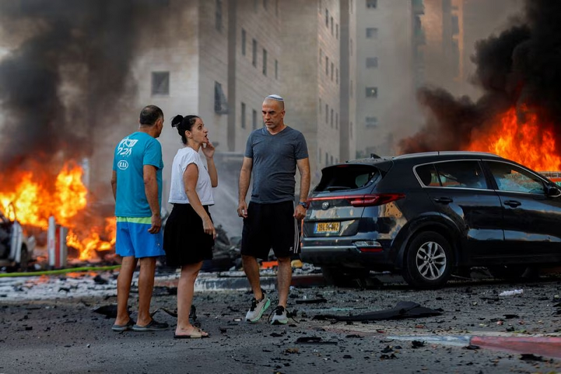 people react near a fire after rockets were launched from the gaza strip in ashkelon israel october 7 2023 photo reuters