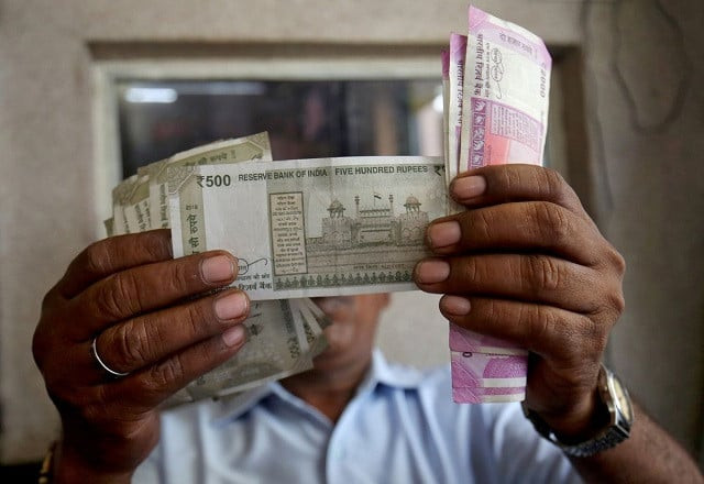 a cashier checks indian rupee notes inside a room at a fuel station in ahmedabad india september 20 2018 photo reuters a cashier checks indian rupee notes inside a room at a fuel station in ahmedabad india september 20 2018 photo reuters