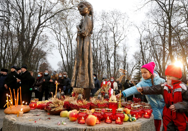 children place ears of wheat as they visit a monument to holodomor victims during a commemoration ceremony marking the 87th anniversary of the famine of 1932 33 in which millions died of hunger in kyiv ukraine november 28 2020 photo reuters