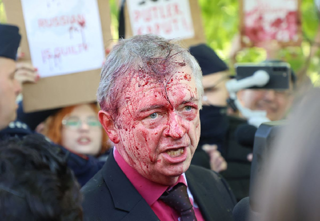 Russian ambassador doused in red by anti-war protesters in Poland
