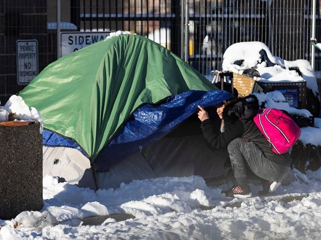 a woman looks on outside of a tent in downtown during a period of cold weather in denver colorado u s december 22 2022 photo reuters a woman looks on outside of a tent in downtown during a period of cold weather in denver colorado u s december 22 2022 photo reuters