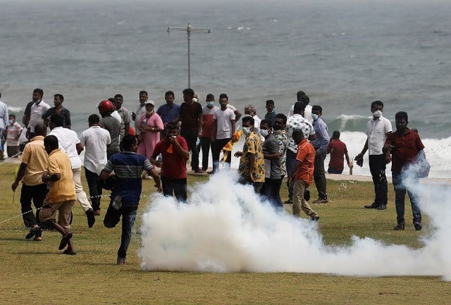 supporters of sri lanka s ruling party run as riot police fire tear gas during a clash with anti government demonstrators amid the country s economic crisis in colombo sri lanka may 9 2022 photo reuters