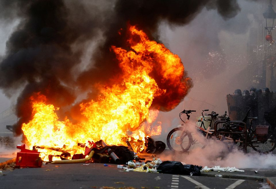 smoke billows from a fire as members of the kurdish community attend a demonstration following a shooting in paris france december 24 2022 reuters sarah meyssonnier