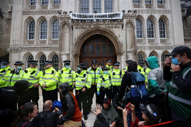 police officers stand in formation as extinction rebellion climate activists protest at the guildhall in london britain august 22 2021 photo reuters police officers stand in formation as extinction rebellion climate activists protest at the guildhall in london britain august 22 2021 photo reuters