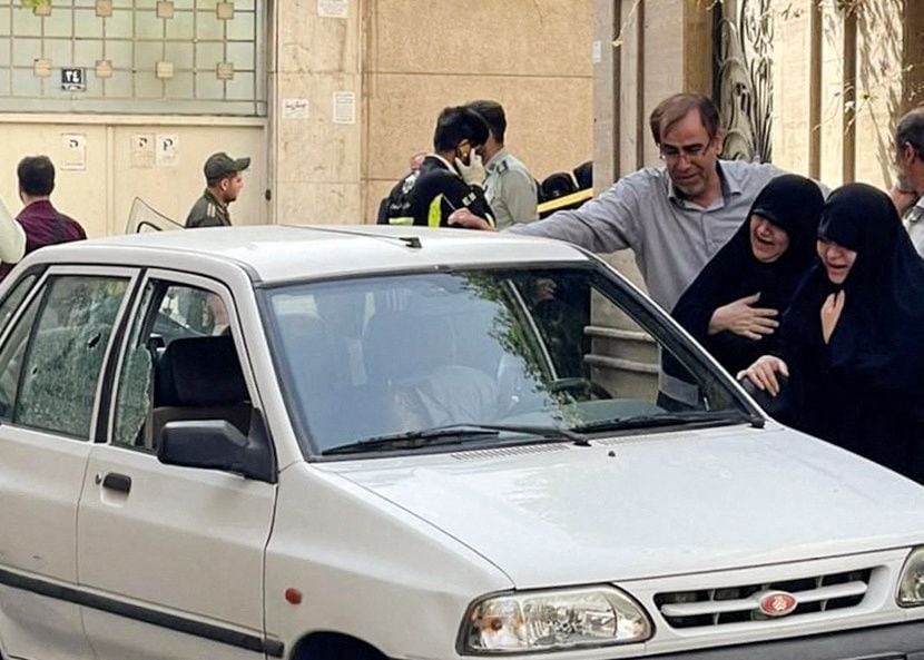 family members of colonel sayad khodai a member of iran s islamic revolution guards corps weep over his body in his car after he was reportedly shot by two assailants in tehran iran may 22 2022 photo reuters