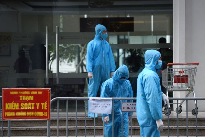 medical workers in protective suits stand outside a quarantined building amid the coronavirus disease covid 19 outbreak in hanoi vietnam january 29 2021 reuters thanh hue