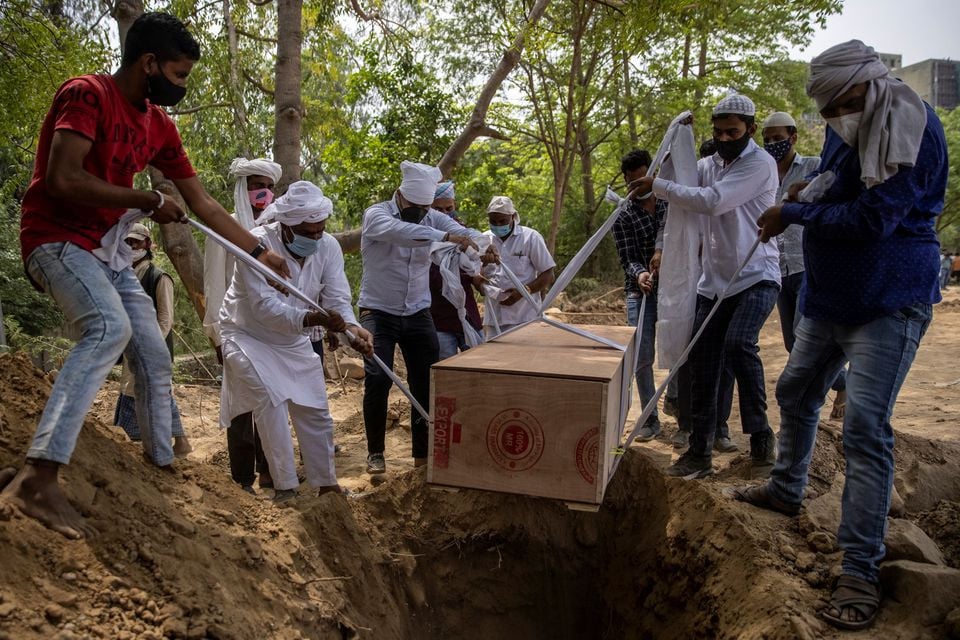 people bury the body of a man who died from the coronavirus disease covid 19 at a graveyard in new delhi india april 16 2021 reuters