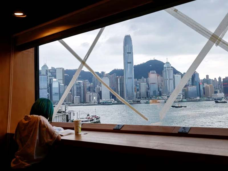 a girl reads a book at a bookstore which windows are taped in anticipation of typhoon saola in hong kong china august 31 2023 photo reuters