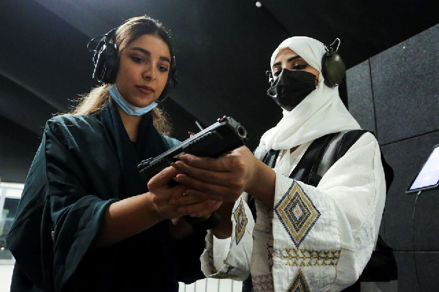 saudi female firearm trainer mona al khurais teaches a saudi woman on safe usage of weapons at the top gun shooting range in riyadh saudi arabia october 28 2021 photo reuters