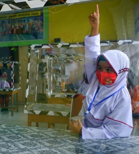 elementary students sit in a classroom using plastics to separate desks in west sumatra province indonesia photo reuters file