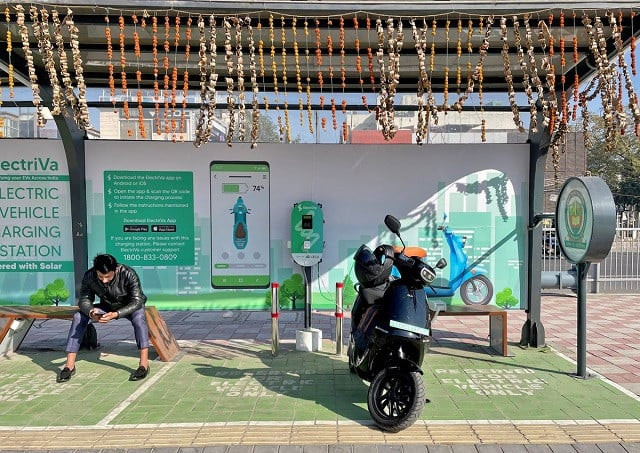 a man checks his mobile phone as he waits while recharging his ola electric scooter at an electric vehicle charging station in new delhi india february 12 2022 photo reuters a man checks his mobile phone as he waits while recharging his ola electric scooter at an electric vehicle charging station in new delhi india february 12 2022 photo reuters
