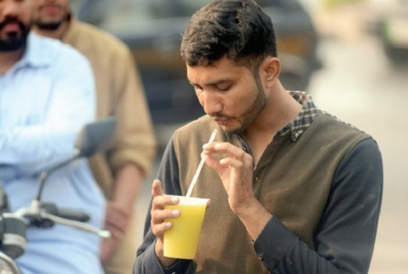 a young man drinks sugar cane juice at a roadside set up in rawalpindi photo agha mahroz express